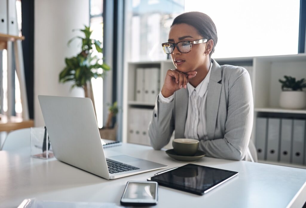 Office, businesswoman and thinking with laptop for solution, reading information and online research. Career, female person and project manager with digital for corporate, report and company progress.